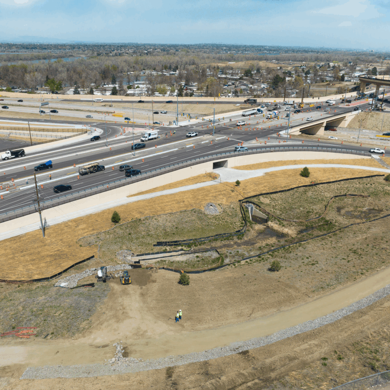 Aerial view of busy highway interchange with cars and construction.