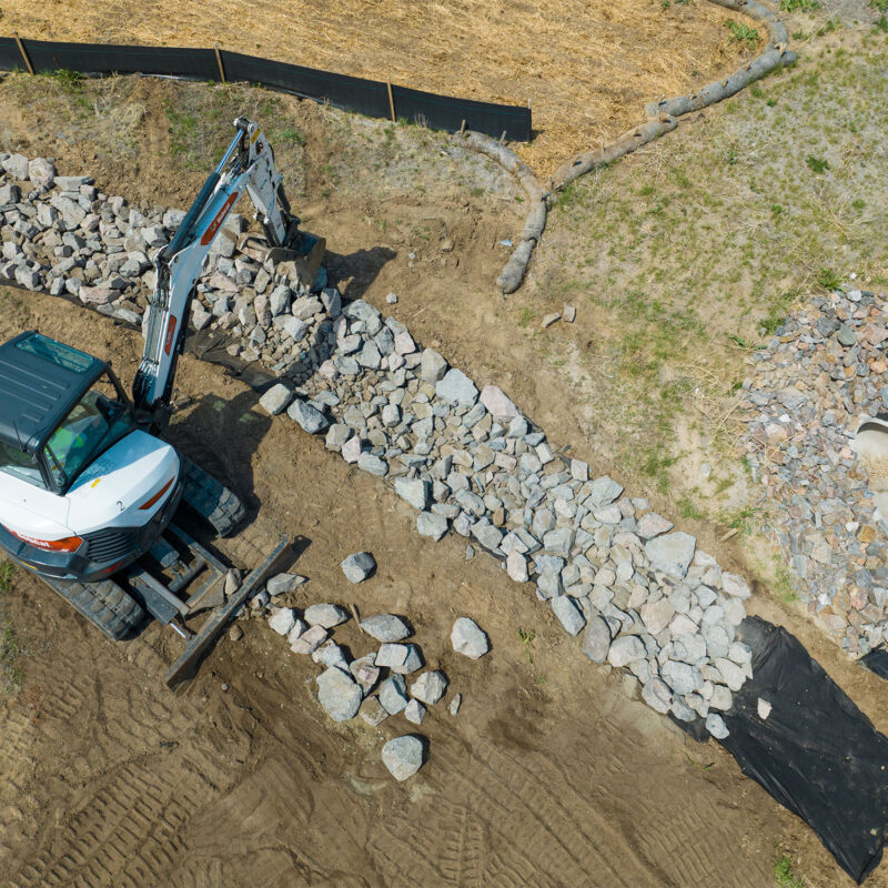 Machine filling channel with rocks