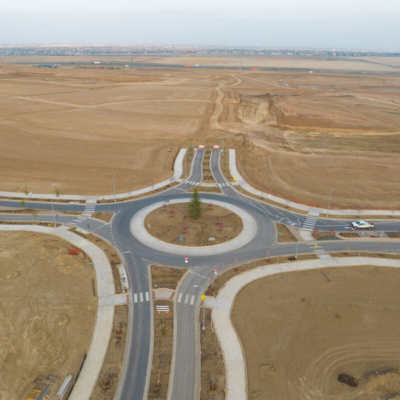 New roundabout and roads amid empty, undeveloped land.