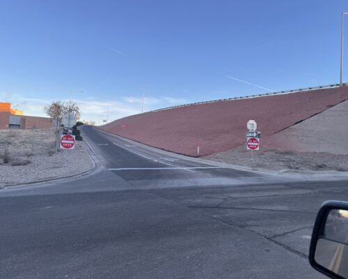 Uphill road to highway with Do Not Enter and Wrong Way signs.