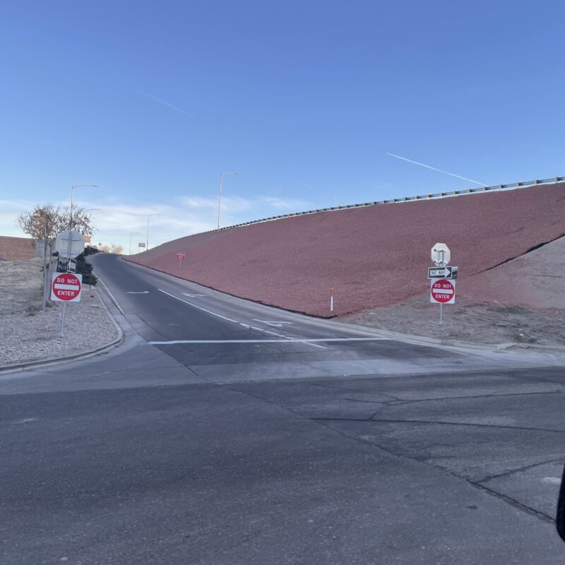 Uphill road to highway with Do Not Enter and Wrong Way signs.